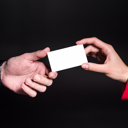 two people passing a business card