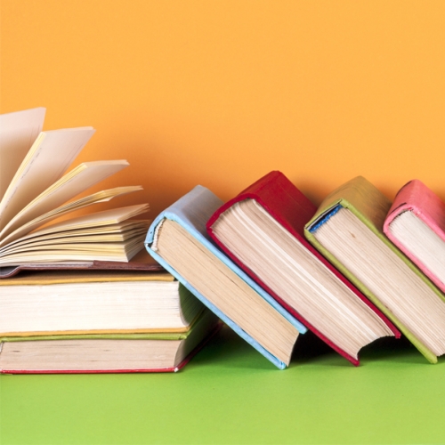 a group of hardback books along a yellow background